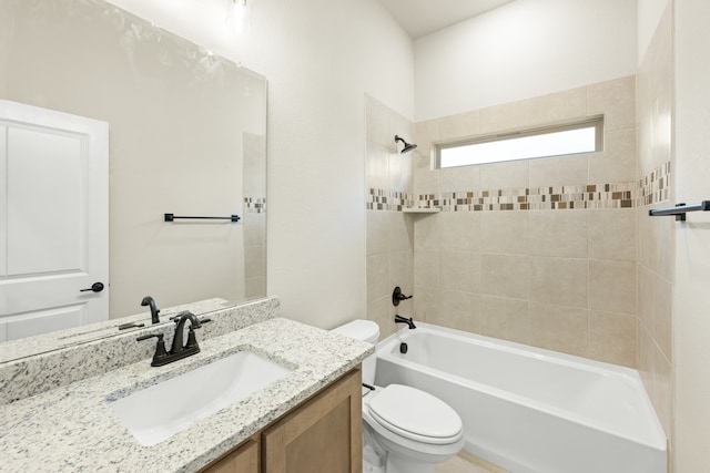 full bathroom with tiled shower / bath, vanity, and toilet