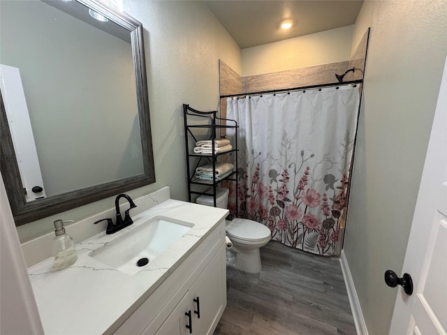 bathroom with toilet, vanity, and wood-type flooring