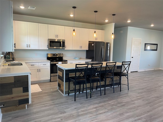 2813 Catfish Ct, Granbury, TX 76048 - kitchen with appliances with stainless steel finishes, light wood-style floors, light countertops, white cabinets, and recessed lighting
