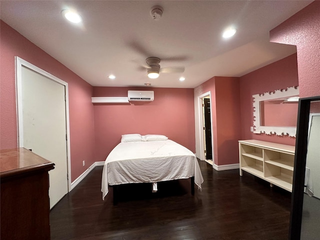 bedroom with baseboards, an AC wall unit, dark wood-type flooring, and recessed lighting