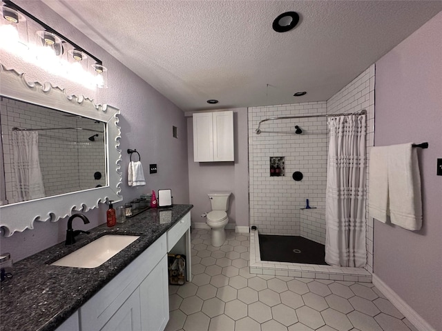 bathroom featuring a stall shower, toilet, tile patterned flooring, a textured ceiling, and vanity