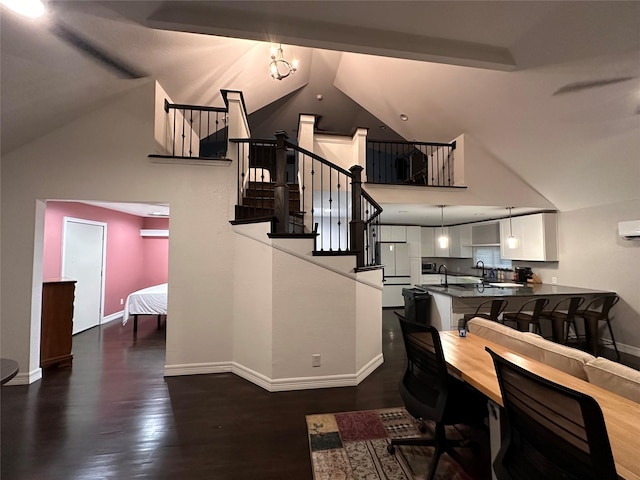 interior space featuring high vaulted ceiling, a sink, dark wood finished floors, and baseboards