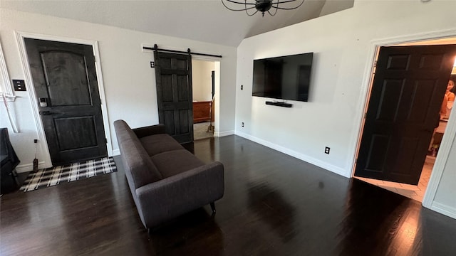 living area featuring dark wood-style flooring, vaulted ceiling, baseboards, and a barn door