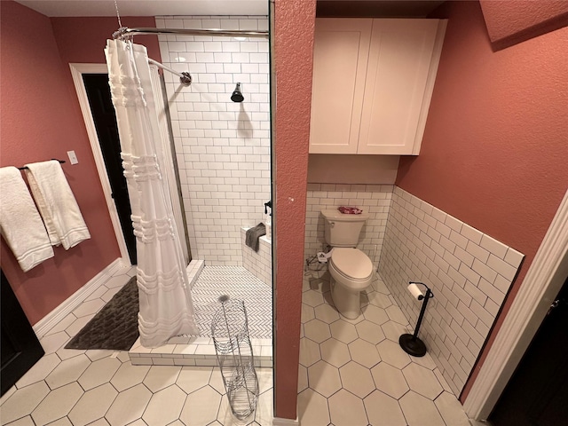 bathroom with toilet, a shower stall, tile walls, and tile patterned flooring