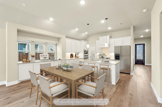 dining space with sink and light hardwood / wood-style flooring