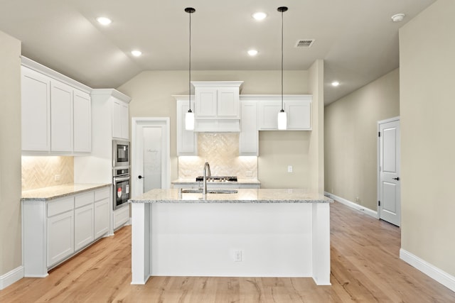 kitchen featuring white cabinetry, appliances with stainless steel finishes, sink, and a center island with sink