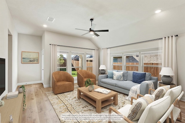 living room featuring light hardwood / wood-style floors, lofted ceiling, and ceiling fan