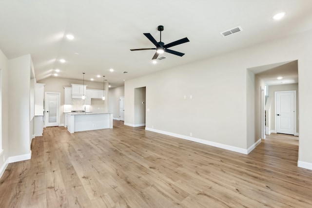 unfurnished living room featuring lofted ceiling, light hardwood / wood-style floors, and ceiling fan