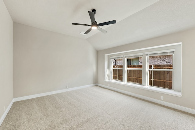 carpeted empty room featuring ceiling fan and vaulted ceiling