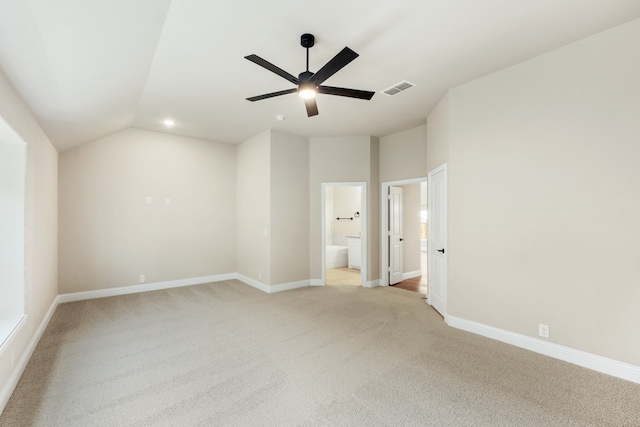 empty room featuring light carpet, ceiling fan, and vaulted ceiling