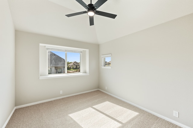 carpeted spare room featuring lofted ceiling and ceiling fan