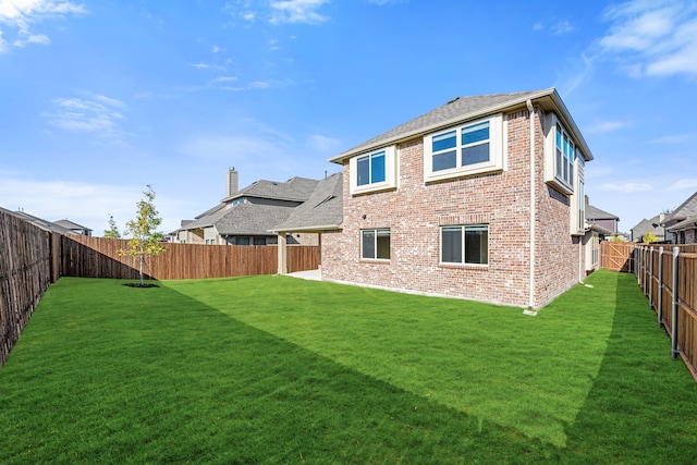 back of house with a patio and a lawn