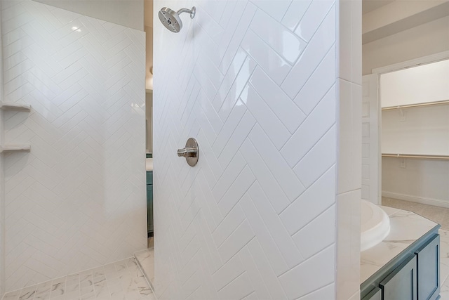 bathroom with a tile shower and vanity