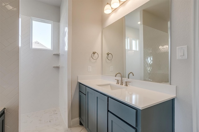 bathroom with vanity and tiled shower