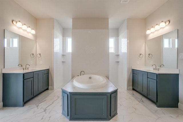 bathroom with vanity, a tub, and plenty of natural light