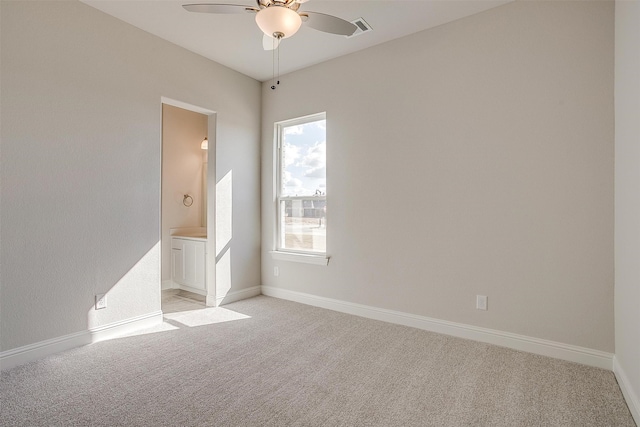 carpeted spare room featuring ceiling fan