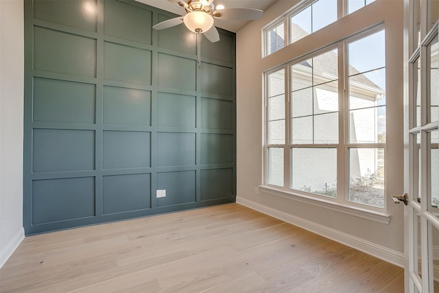 empty room featuring light hardwood / wood-style floors, a wealth of natural light, and ceiling fan