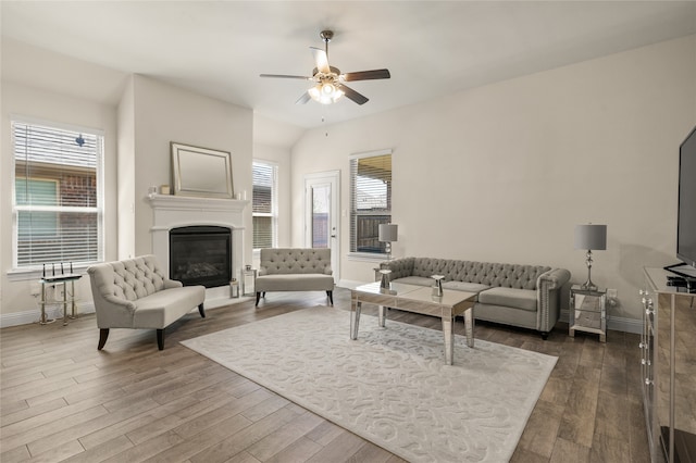 living room featuring a healthy amount of sunlight, vaulted ceiling, ceiling fan, and hardwood / wood-style flooring