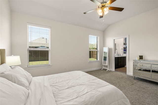 carpeted bedroom featuring ceiling fan, vaulted ceiling, and ensuite bath