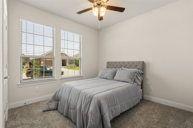 carpeted bedroom featuring multiple windows and ceiling fan