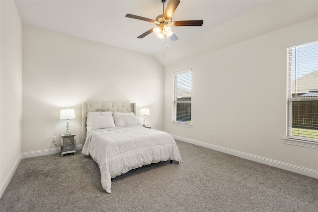 carpeted bedroom with multiple windows, vaulted ceiling, and ceiling fan