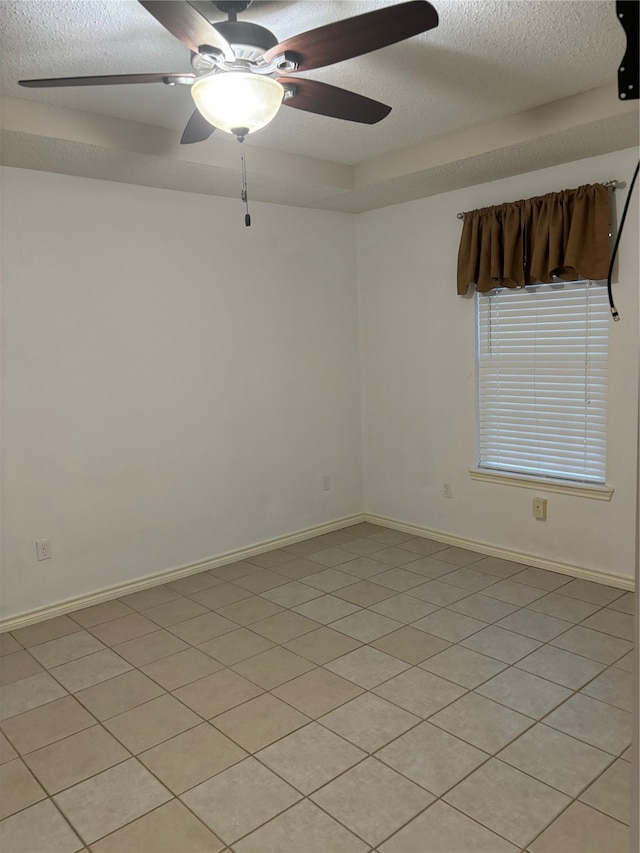 tiled spare room with ceiling fan and a textured ceiling