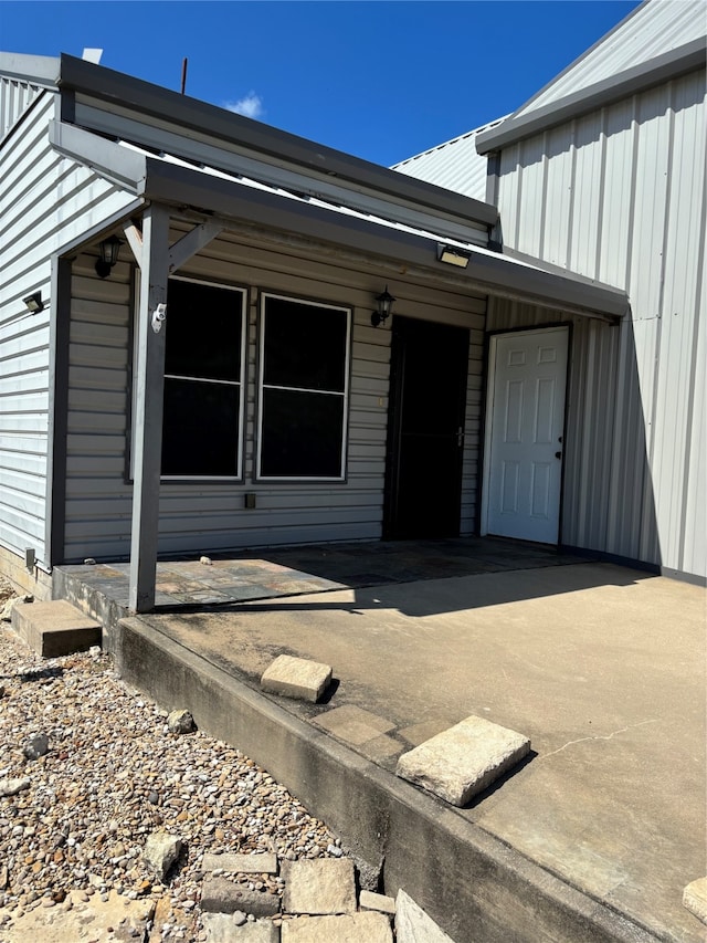 view of exterior entry with a patio area