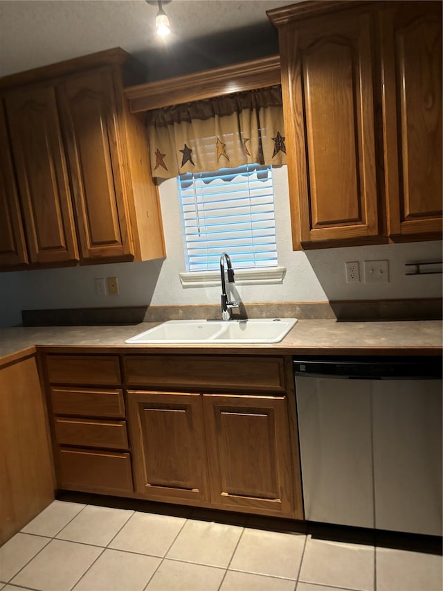 kitchen featuring sink, stainless steel dishwasher, and light tile flooring