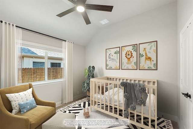 bedroom featuring ceiling fan, lofted ceiling, and a nursery area