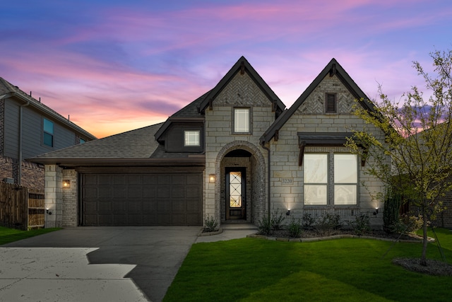 french provincial home featuring a lawn and a garage