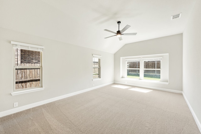 carpeted empty room featuring lofted ceiling, a healthy amount of sunlight, and ceiling fan