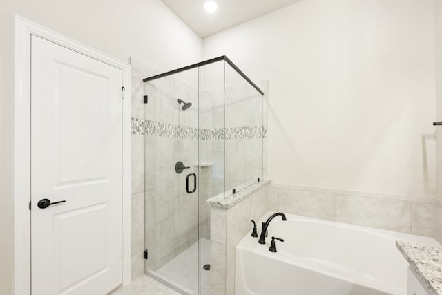 bathroom with vanity and shower with separate bathtub