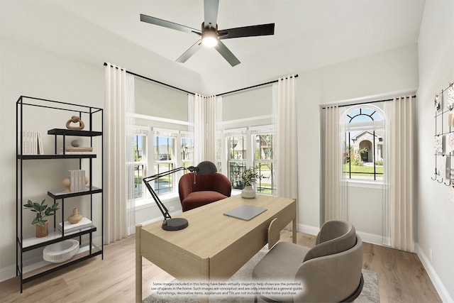 office with light wood-type flooring and ceiling fan