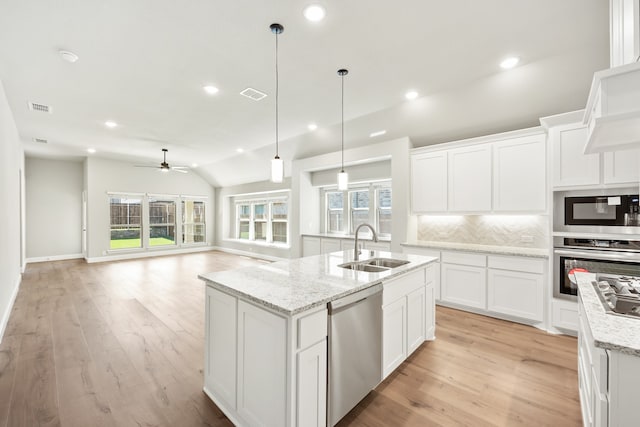 kitchen with appliances with stainless steel finishes, white cabinetry, and plenty of natural light