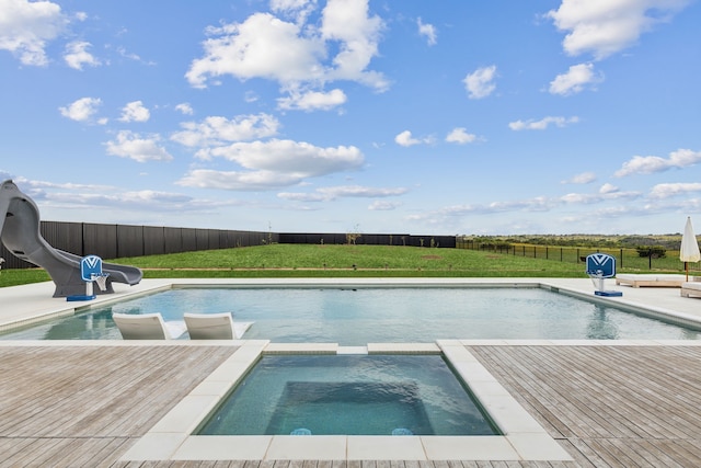 view of swimming pool with a lawn, a wooden deck, an in ground hot tub, and a water slide