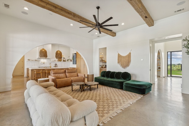 living room with ceiling fan and beamed ceiling