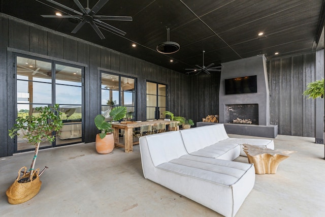 interior space with wooden walls, concrete flooring, and a wealth of natural light