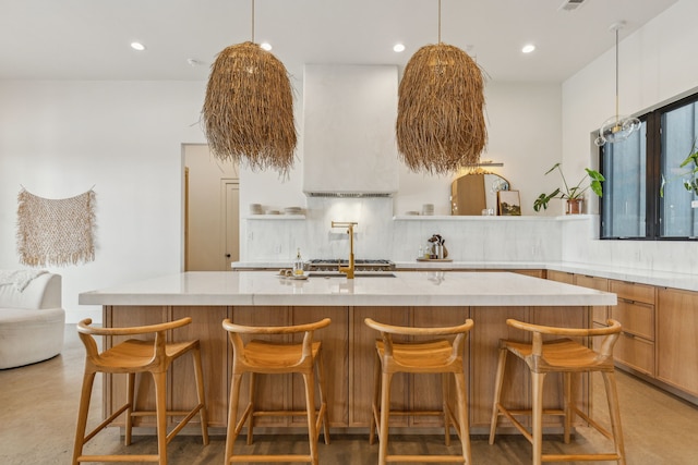 kitchen featuring a large island, pendant lighting, backsplash, and a kitchen breakfast bar