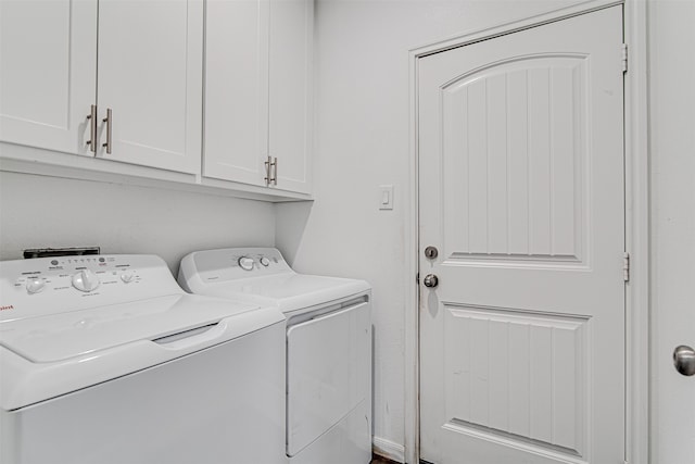 clothes washing area with cabinets and independent washer and dryer