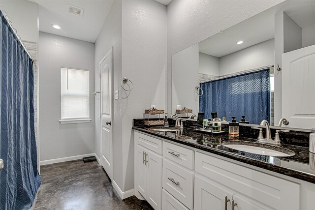 bathroom featuring double vanity and concrete floors