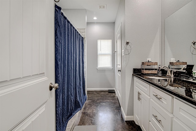 bathroom featuring baseboards, a textured wall, curtained shower, finished concrete floors, and vanity