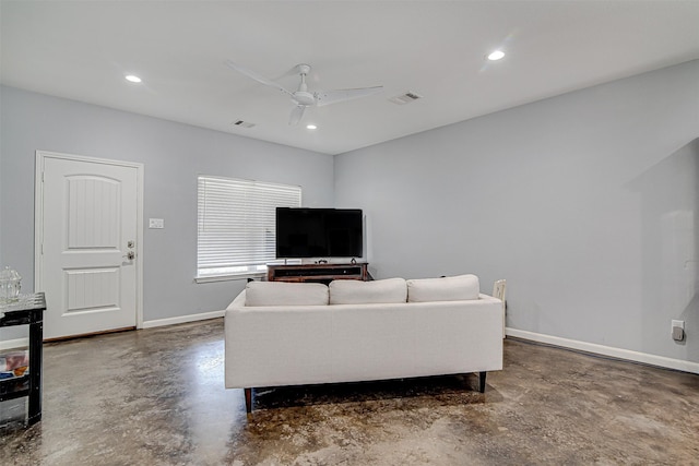 living area with concrete floors, baseboards, and recessed lighting