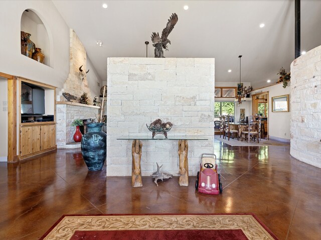 interior space featuring a stone fireplace and an inviting chandelier