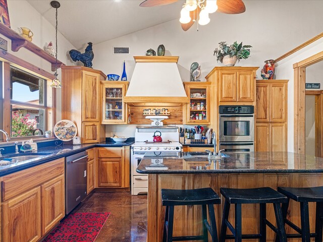 kitchen with lofted ceiling, sink, a kitchen island, appliances with stainless steel finishes, and custom range hood