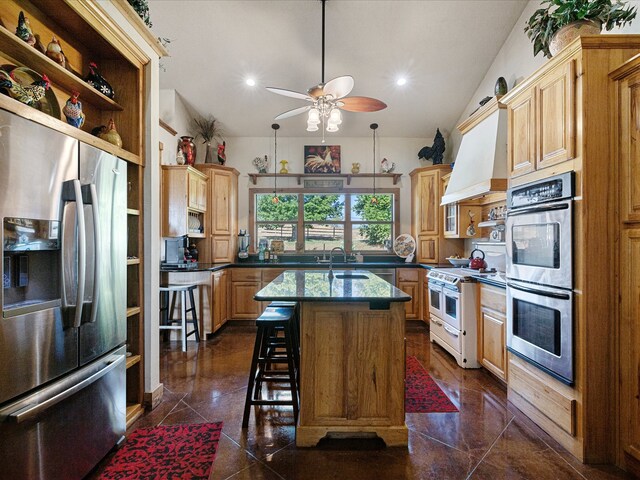 kitchen featuring sink, a kitchen island with sink, stainless steel appliances, a kitchen breakfast bar, and vaulted ceiling