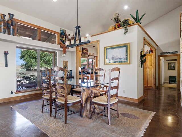 dining space featuring a towering ceiling and a notable chandelier