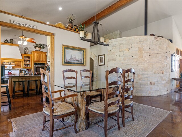 tiled dining room with vaulted ceiling with beams and ceiling fan with notable chandelier