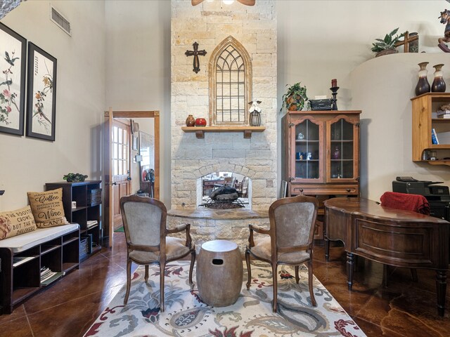 dining area featuring a stone fireplace and ceiling fan