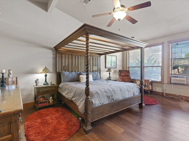 bedroom featuring dark hardwood / wood-style flooring, beamed ceiling, a textured ceiling, cooling unit, and ceiling fan