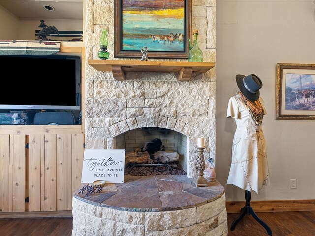 interior details with hardwood / wood-style flooring and a stone fireplace